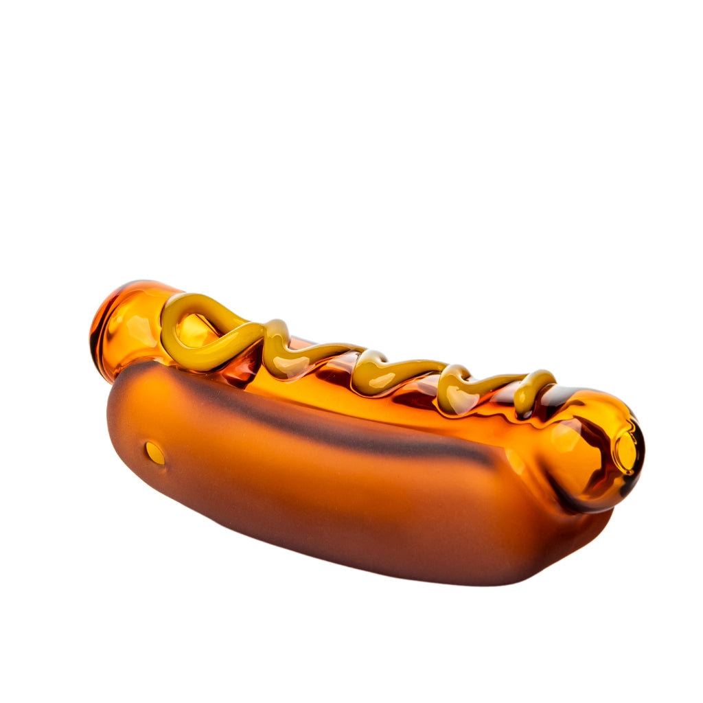 BigFun! Glizzy Hand Pipe in amber glass shaped like a hot dog with mustard swirl, angled view