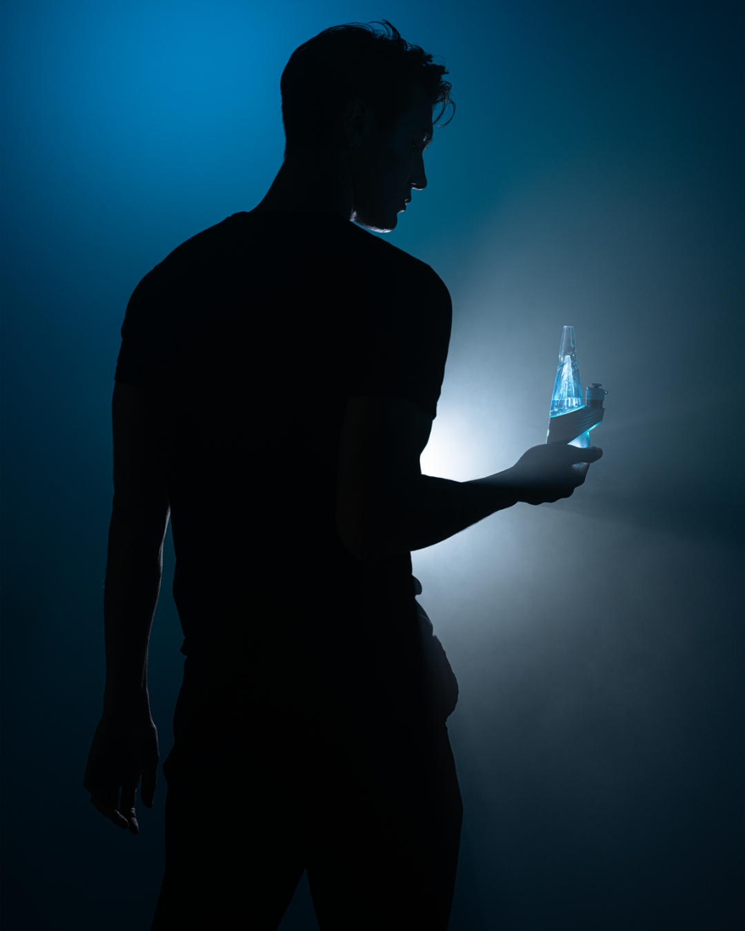 Silhouette of a man holding a glowing Puffco Peak Pro Glacier